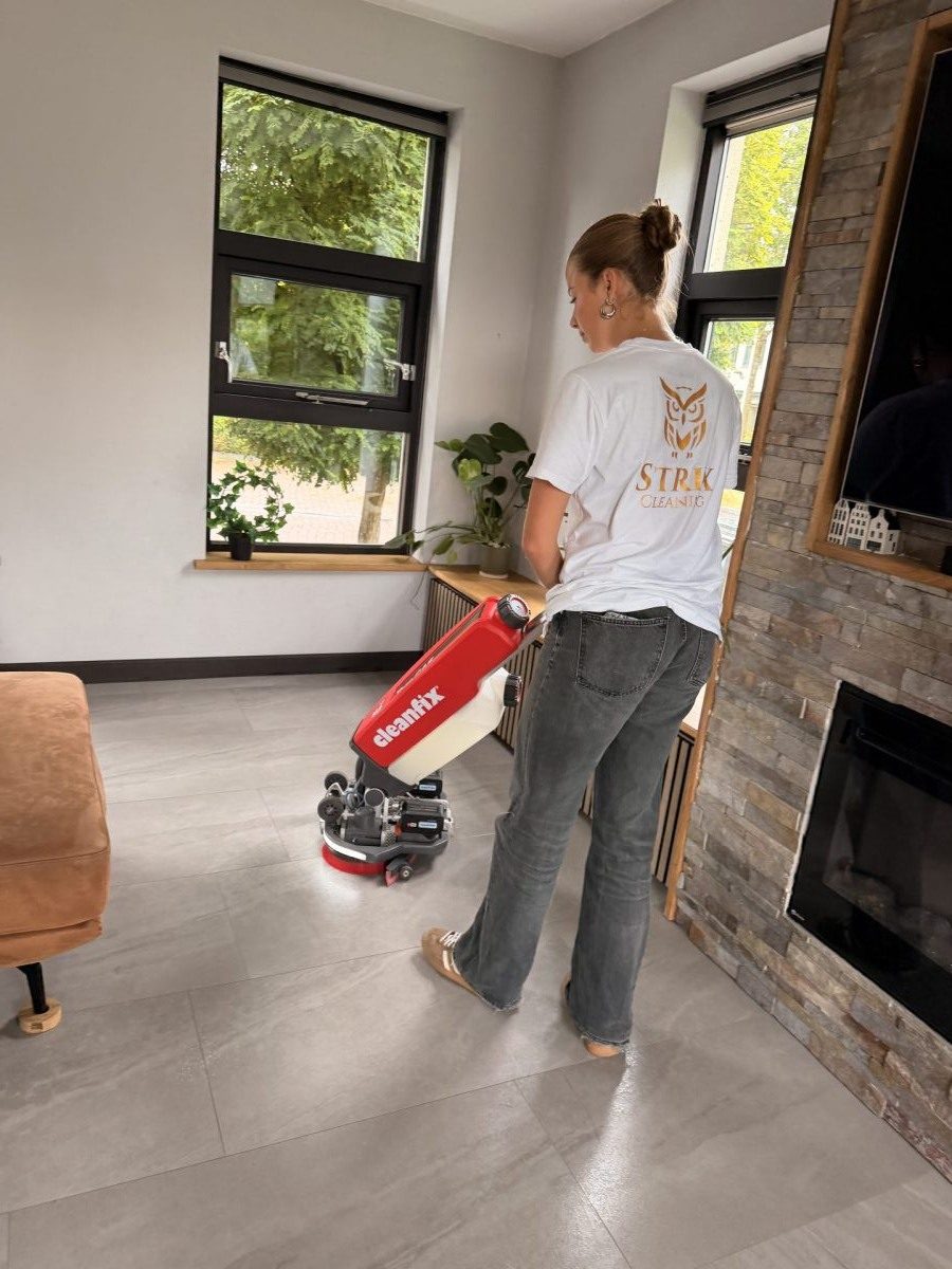 Schoonmaker van Strix Cleaning reinigt een vloer met een professionele schrobmachine