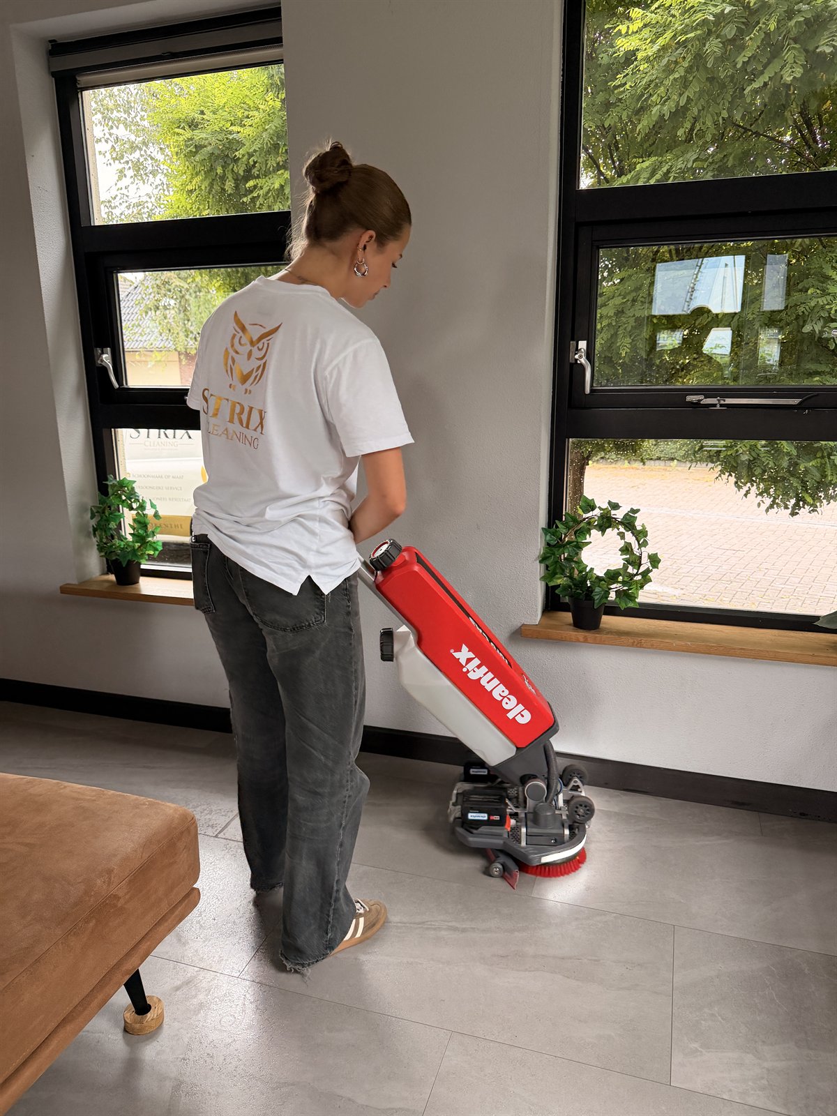 Medewerker van Strix Cleaning reinigt een vloer met een vloermachine